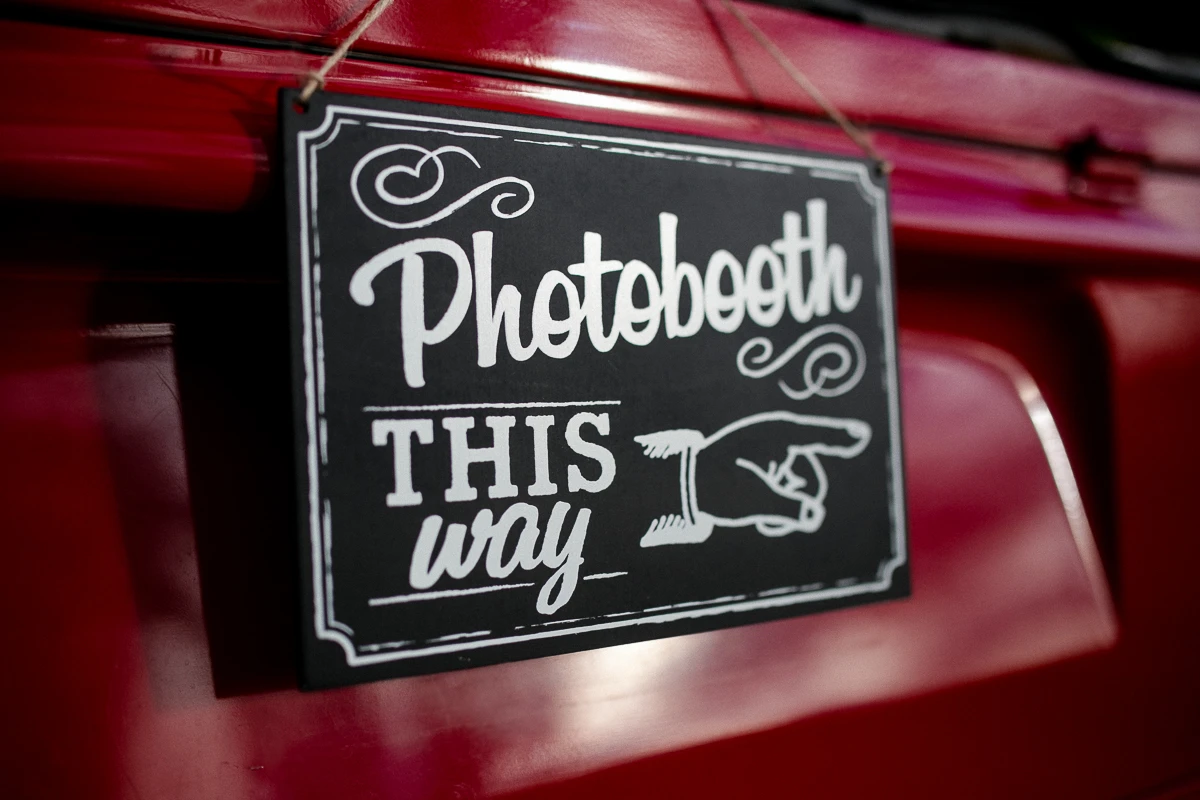 Photobooth-Hinweisschild am roten VW-Bus